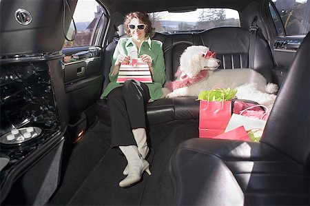 Woman and her Poodle sitting in limo Stock Photo - Premium Royalty-Free, Code: 673-02139483