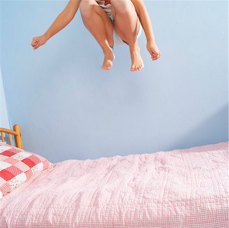 Girl jumping on bed Stock Photo - Premium Royalty-Free, Code: 673-02139551