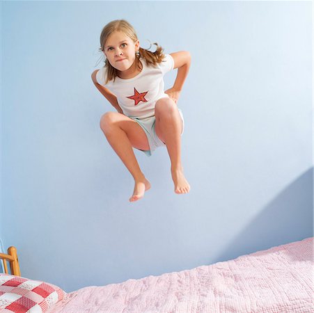 Girl jumping on bed Stock Photo - Premium Royalty-Free, Code: 673-02139552
