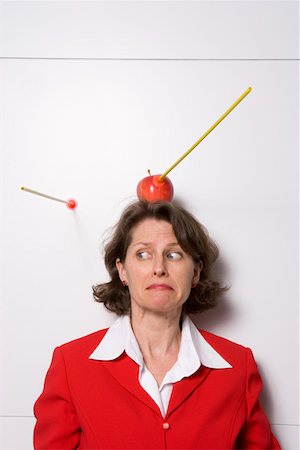 Shooting an apple off businesswoman's head Stock Photo - Premium Royalty-Free, Code: 673-02139636