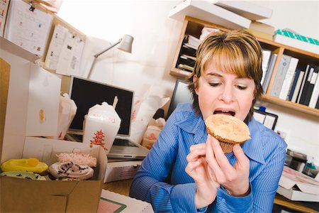 Office worker eating at her desk Stock Photo - Premium Royalty-Free, Code: 673-02139663