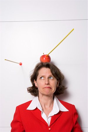 Shooting apple off businesswoman's head Stock Photo - Premium Royalty-Free, Code: 673-02139703