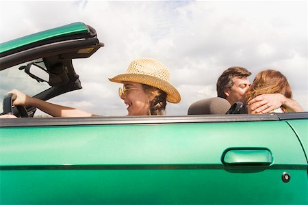 Girl pretending to drive while parents kiss Foto de stock - Sin royalties Premium, Código: 673-02139715