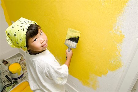 Child concentrating on painting wall Stock Photo - Premium Royalty-Free, Code: 673-02139864