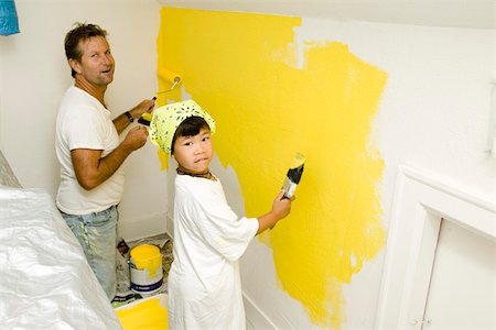 Man and child painting wall Stock Photo - Premium Royalty-Free, Code: 673-02139924