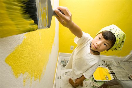 Child concentrating on painting wall Stock Photo - Premium Royalty-Free, Code: 673-02139925