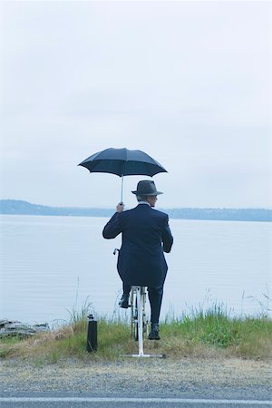 elderly humorous - Businessman riding stationary bike near lake Stock Photo - Premium Royalty-Free, Code: 673-02140028