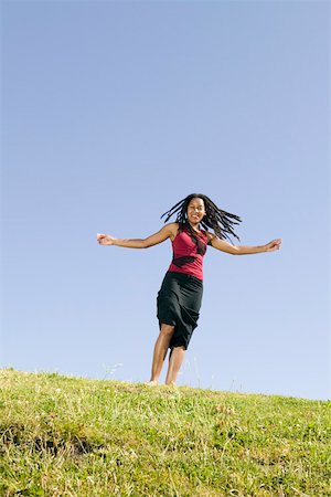 Young woman running on grassy hill Stock Photo - Premium Royalty-Free, Code: 673-02140030