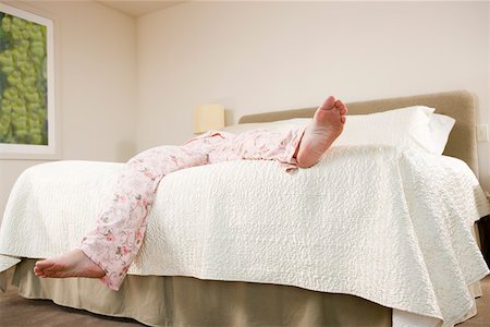 Legs of woman sprawled on bed in pajamas Foto de stock - Sin royalties Premium, Código: 673-02140394