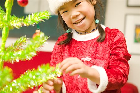 Happy girl decorating Christmas tree Foto de stock - Sin royalties Premium, Código: 673-02140592