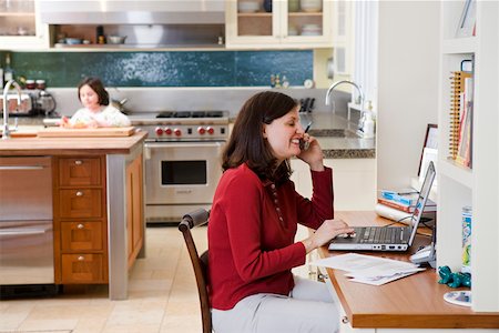 family computer kitchen - Mère en utilisant le téléphone et l'ordinateur dans la cuisine Photographie de stock - Premium Libres de Droits, Code: 673-02140782