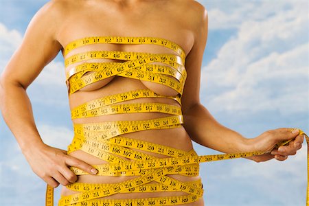 disrobed - Midsection of nude woman wrapped in measuring tape Stock Photo - Premium Royalty-Free, Code: 673-02141126