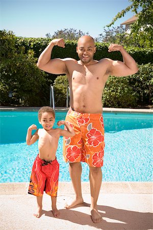 shaving imitating dad - Father and son flexing muscles by pool Stock Photo - Premium Royalty-Free, Code: 673-02141439