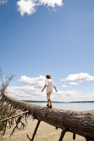 facing away - Young boy balancing on fallen tree Stock Photo - Premium Royalty-Free, Code: 673-02141507