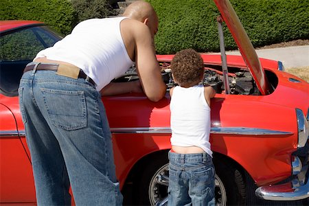 facing away - Father and son examining under car hood Stock Photo - Premium Royalty-Free, Code: 673-02141574