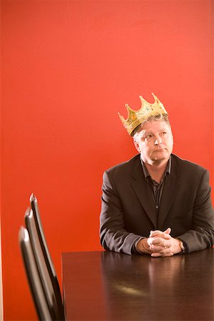 Businessman wearing gold crown in conference room Stock Photo - Premium Royalty-Free, Code: 673-02142070