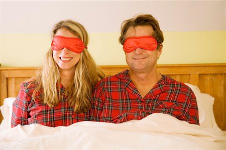 Couple sitting in bed wearing eye masks Stock Photo - Premium Royalty-Free, Code: 673-02142136