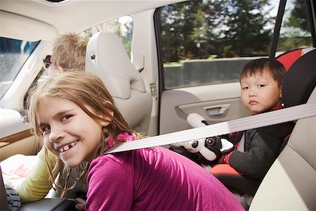 family inside car - Young girl leaning forward in backseat of car Stock Photo - Premium Royalty-Free, Code: 673-02142665