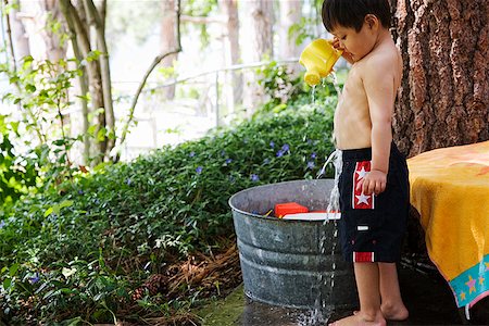 Young boy dumping water on himself Stock Photo - Premium Royalty-Free, Code: 673-02142685