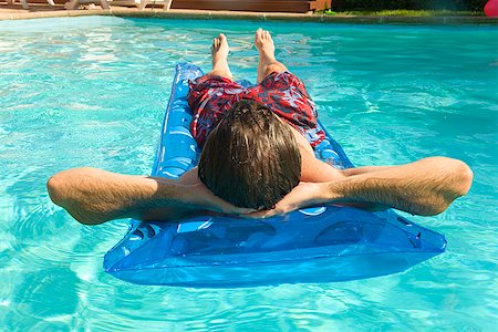 facing away - Man on float in swimming pool Stock Photo - Premium Royalty-Free, Code: 673-02143078