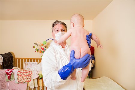 Father in decontamination suit holding baby Stock Photo - Premium Royalty-Free, Code: 673-02143248