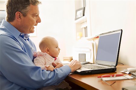 daughter sitting on dad lap - Businessman working with baby on lap Stock Photo - Premium Royalty-Free, Code: 673-02143256