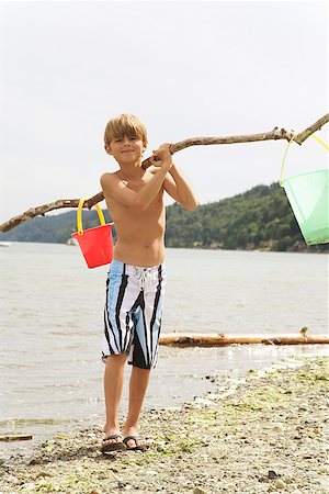 Boy carrying buckets at beach Stock Photo - Premium Royalty-Free, Code: 673-02143314