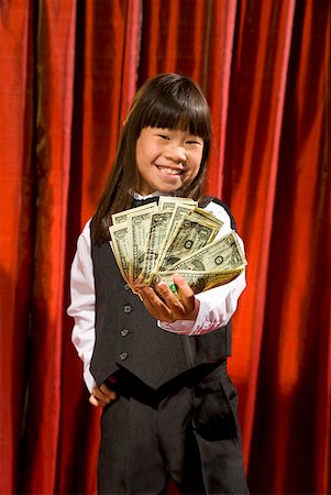 funny tuxedos - Asian girl holding money on stage Stock Photo - Premium Royalty-Free, Code: 673-02143354