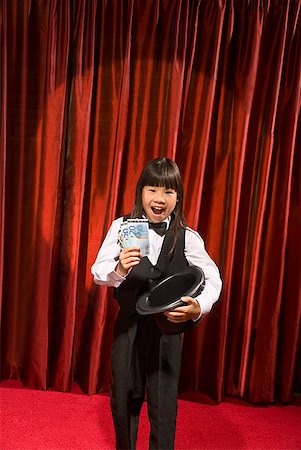 stage show - Asian girl pulling money out of top hat Stock Photo - Premium Royalty-Free, Code: 673-02143356