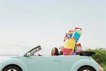 packed - African woman in convertible with shopping bags Stock Photo - Premium Royalty-Free, Code: 673-02143385