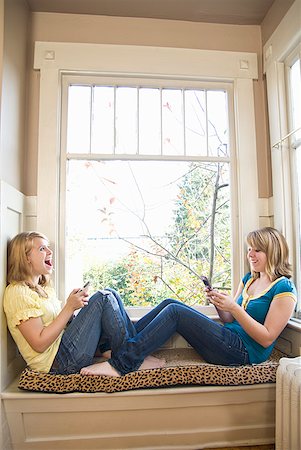 Teenaged sisters dialing cell phones Stock Photo - Premium Royalty-Free, Code: 673-02143581