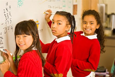 schoolmate - Multi-ethnic girls writing on whiteboard Stock Photo - Premium Royalty-Free, Code: 673-02143651