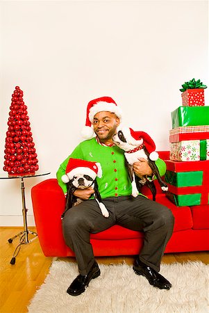 African man and dogs wearing Santa Claus hats Stock Photo - Premium Royalty-Free, Code: 673-02143821