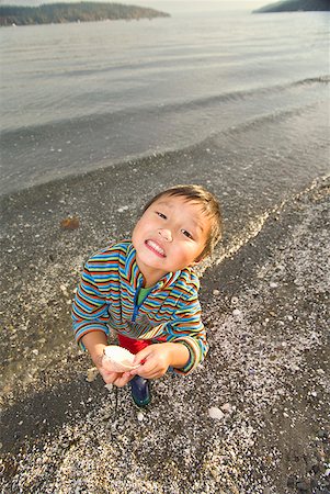 Asian boy holding seashell Stock Photo - Premium Royalty-Free, Code: 673-02143932