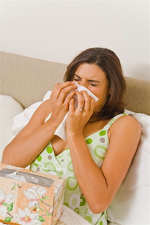 Woman blowing nose in bed Stock Photo - Premium Royalty-Free, Code: 673-02216373