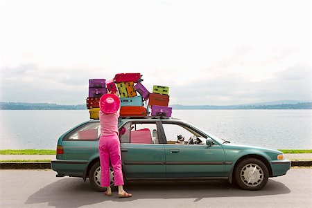 packed - Woman adjusting stack of colorful suitcases on top of car Stock Photo - Premium Royalty-Free, Code: 673-02216517