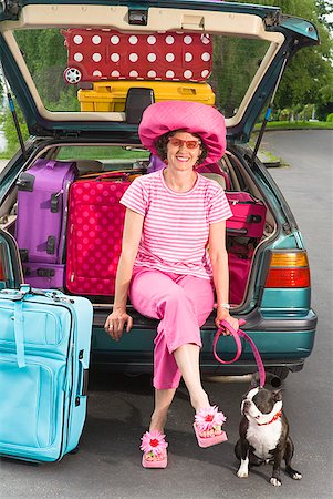 Woman and Boston Terrier dog posing with car loaded with colorful suitcases Stock Photo - Premium Royalty-Free, Code: 673-02216521