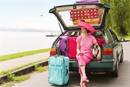 Woman and Boston Terrier dog posing with car loaded with colorful suitcases Stock Photo - Premium Royalty-Free, Code: 673-02216522