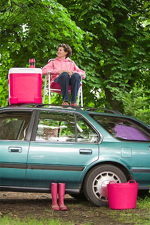 Woman picnicking on top of car Stock Photo - Premium Royalty-Free, Code: 673-02216555