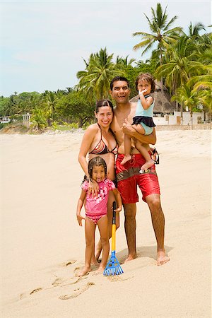 Couple with their children standing on the beach Stock Photo - Premium Royalty-Free, Code: 673-02386503