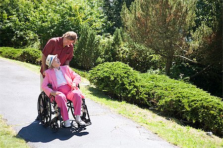 Man assisting his disabled mother in a wheelchair Stock Photo - Premium Royalty-Free, Code: 673-02386531