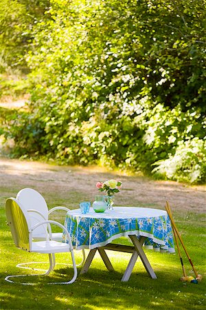 Two chairs with a table and croquet mallets in a garden Stock Photo - Premium Royalty-Free, Code: 673-02386553