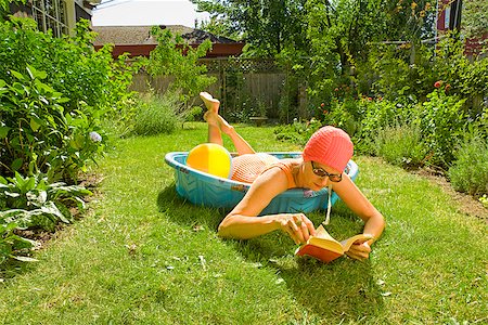 Woman lying in a wading pool and reading a book Stock Photo - Premium Royalty-Free, Code: 673-02386581