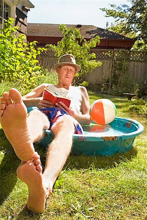 simsearch:673-02386607,k - Man reading a book in a wading pool Stock Photo - Premium Royalty-Free, Code: 673-02386602