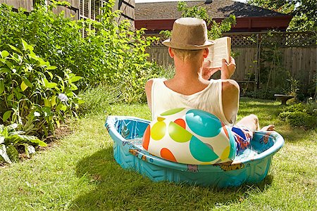 simsearch:673-02386607,k - Rear view of a man reading a book in a wading pool Stock Photo - Premium Royalty-Free, Code: 673-02386603