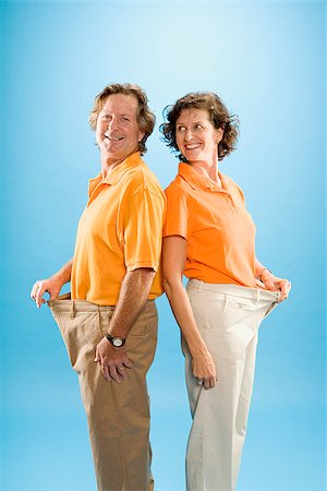 Man and a woman wearing loose pants to show their weight loss Stock Photo - Premium Royalty-Free, Code: 673-02386626