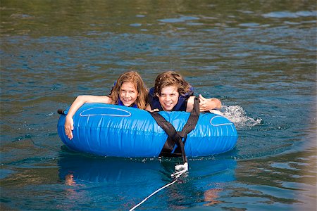 preteen girl floating on water - Boy on an inflatable ring with his sister in a lake Stock Photo - Premium Royalty-Free, Code: 673-02386697