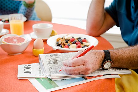 Couple having breakfast and checking classifieds Stock Photo - Premium Royalty-Free, Code: 673-02801255