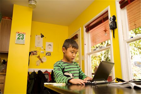 boy with laptop at kitchen table Stock Photo - Premium Royalty-Free, Code: 673-03826550