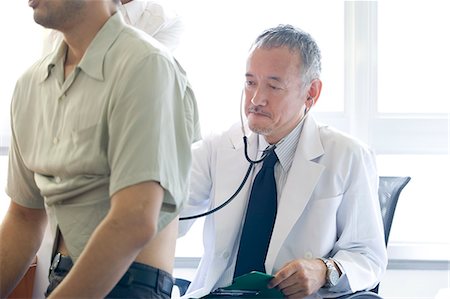simsearch:685-02938374,k - Doctor examining patient with stethoscope Stock Photo - Premium Royalty-Free, Code: 685-02938352
